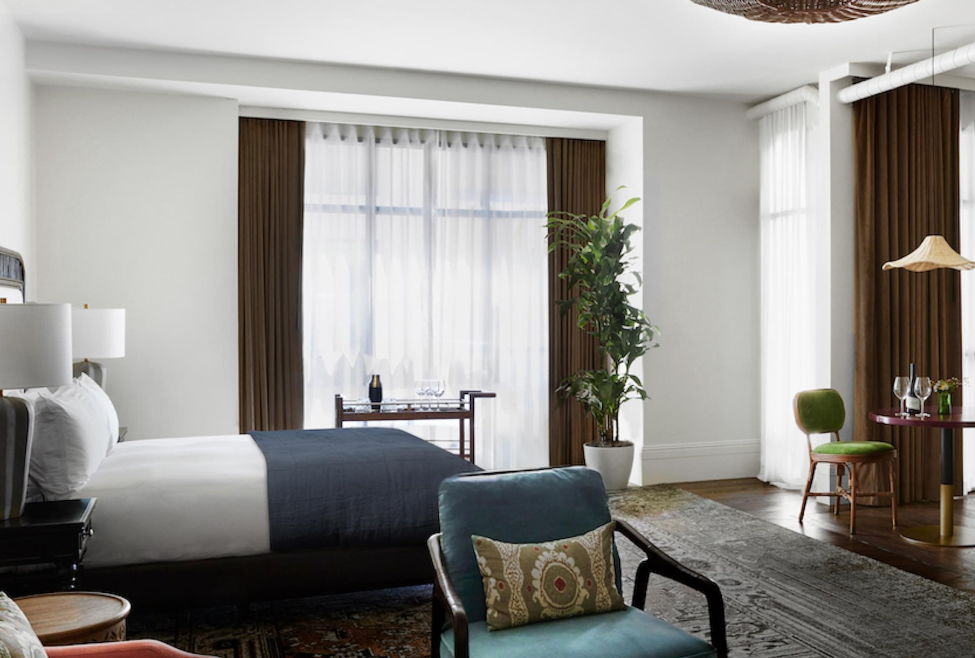 a room with a bed and chairs